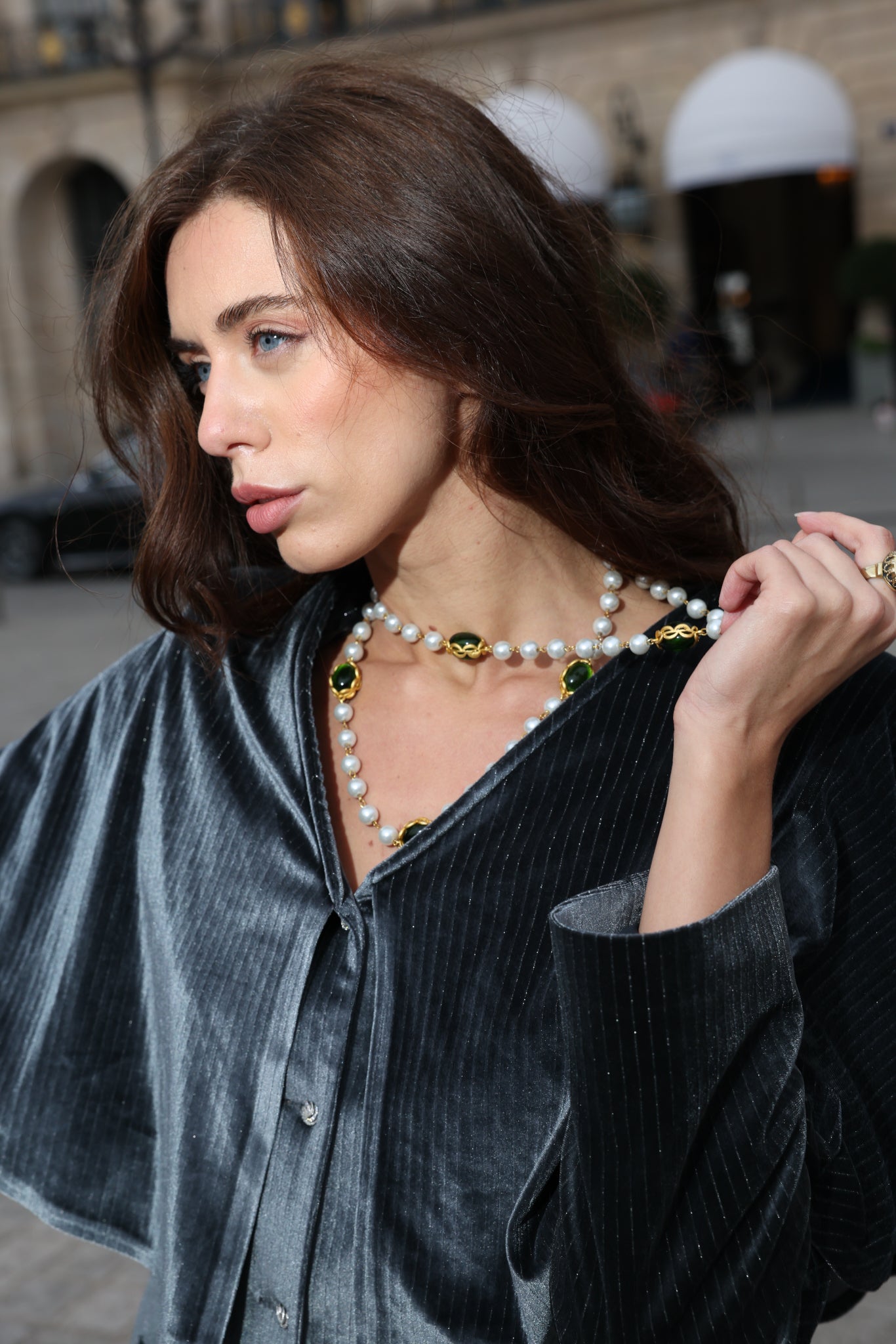 Woman wearing a pearl necklace with a gray background in Paris. 