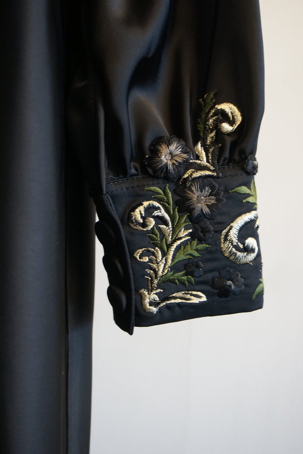 Black fabric with silk handmade embroidery on a white background. 
